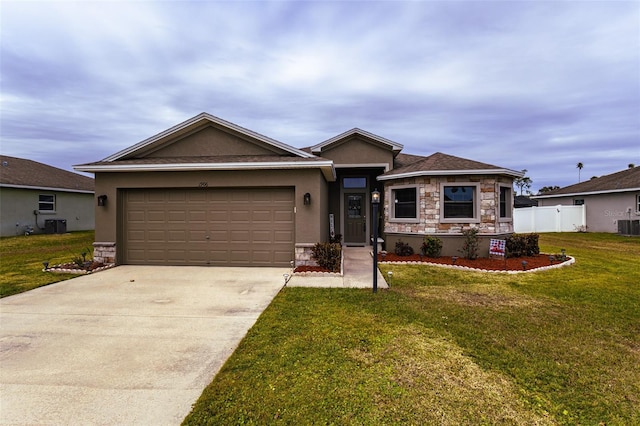 view of front of house featuring a front lawn, central air condition unit, and a garage