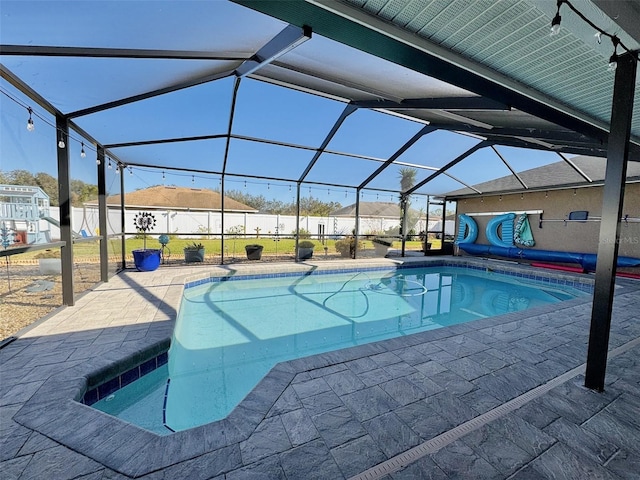 view of swimming pool featuring a lanai and a patio area