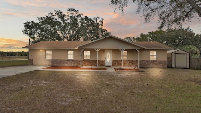 view of front of house with a storage shed and a yard