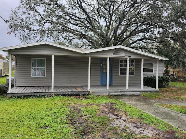 view of front of house featuring covered porch and a front lawn