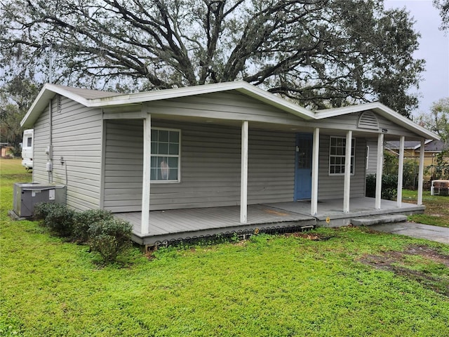 view of front of property with a front lawn, cooling unit, and a porch