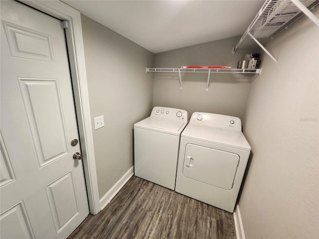 laundry area with dark wood finished floors, laundry area, baseboards, and washer and clothes dryer