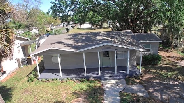 view of front of home with covered porch and a front lawn