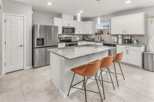 kitchen with a kitchen island, stainless steel appliances, white cabinets, and sink