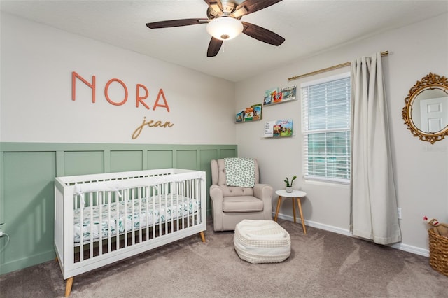 bedroom featuring a crib, carpet floors, and ceiling fan