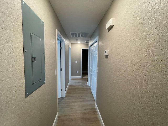 hall featuring electric panel and wood-type flooring