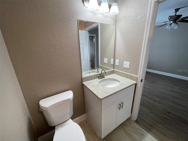 bathroom featuring ceiling fan, hardwood / wood-style floors, vanity, and toilet