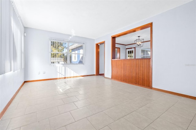 unfurnished room featuring an inviting chandelier and light tile patterned floors