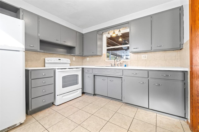 kitchen with white appliances, light tile patterned floors, gray cabinetry, and sink