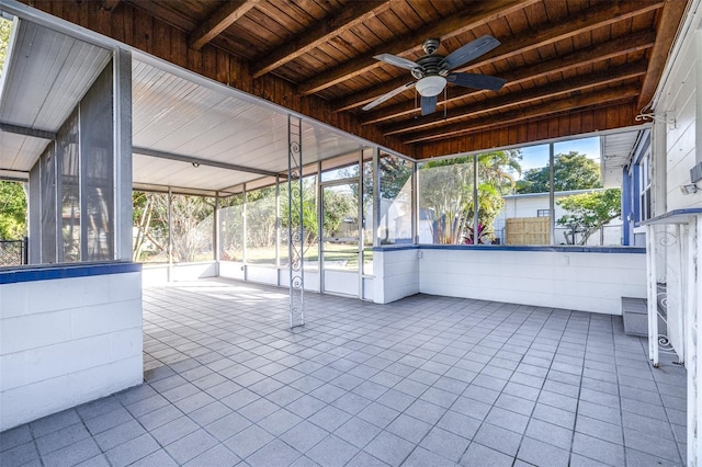 unfurnished sunroom with ceiling fan, wood ceiling, and beamed ceiling