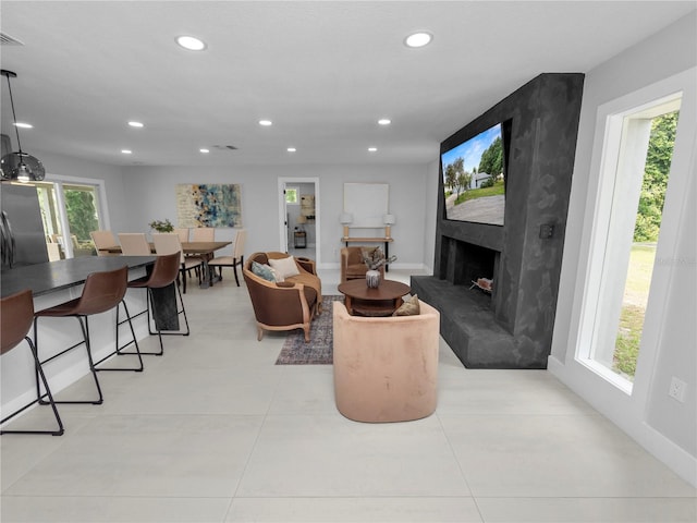 tiled living room featuring a healthy amount of sunlight and a high end fireplace