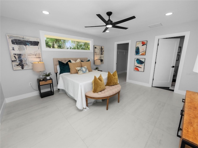 bedroom with a walk in closet, ceiling fan, and a closet