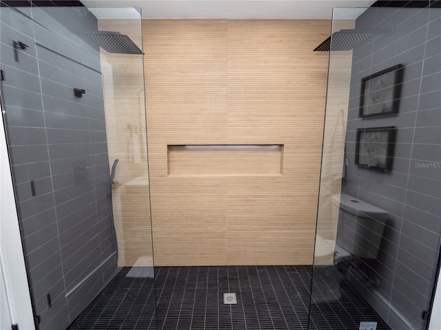 bathroom with tile walls, tiled shower, and tile patterned floors