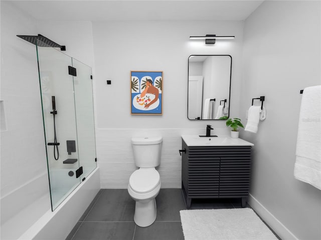 full bathroom featuring tile patterned flooring, toilet, vanity, tile walls, and bath / shower combo with glass door