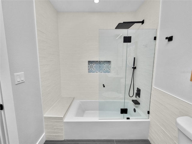 bathroom with toilet and tiled shower / bath combo