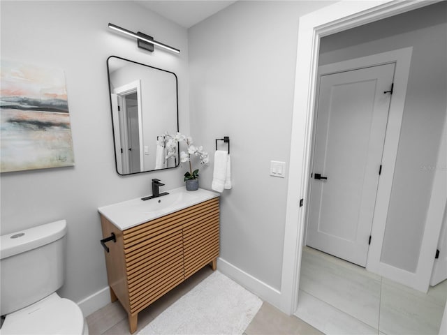 bathroom with tile patterned flooring, vanity, and toilet