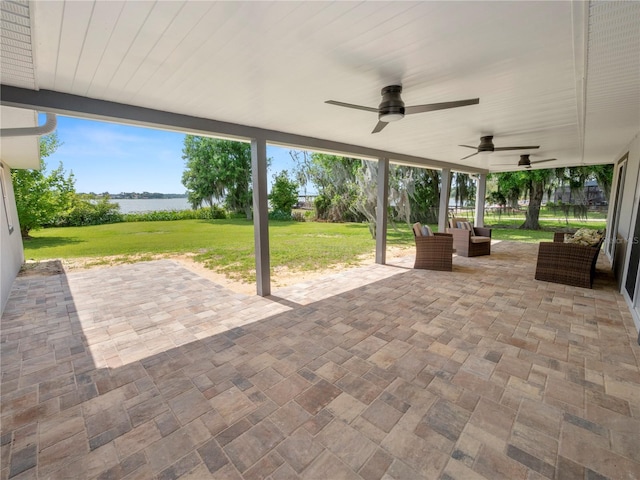 view of patio / terrace featuring ceiling fan, an outdoor hangout area, and a water view