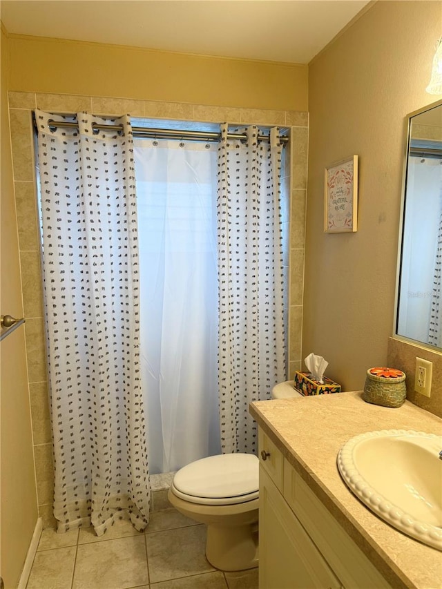 bathroom with toilet, vanity, tile patterned flooring, and walk in shower