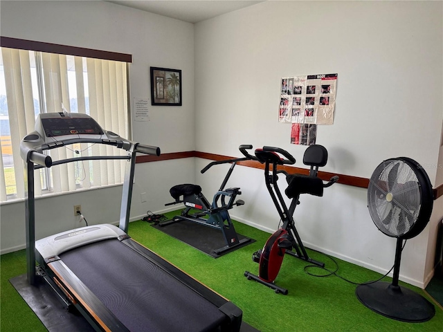 workout area with a wealth of natural light and dark carpet