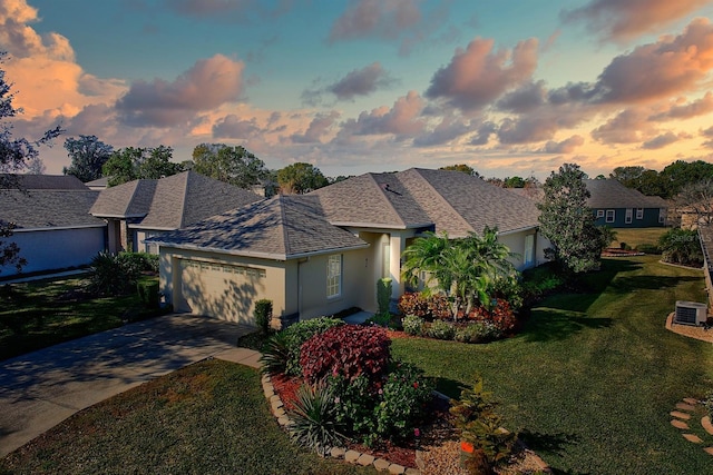 view of front of property with a garage and a lawn