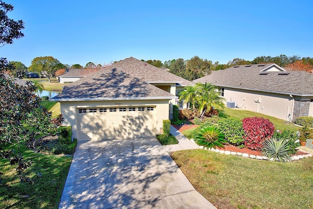 view of front of property featuring a garage, central AC unit, a front yard, and a water view