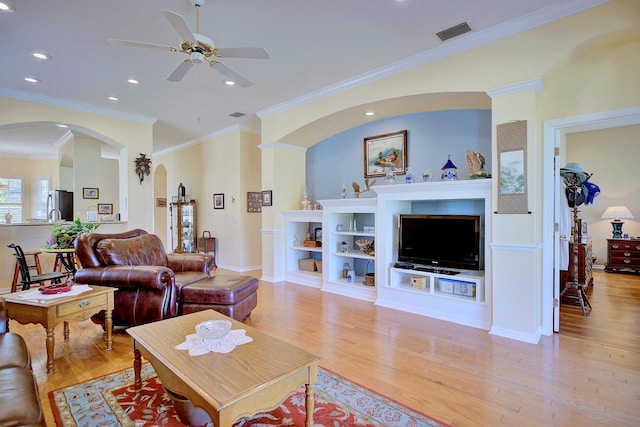 living room featuring ceiling fan, crown molding, and light hardwood / wood-style flooring