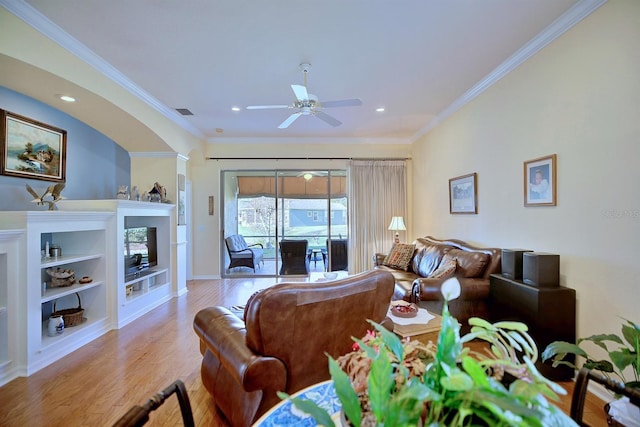 living room with crown molding, ceiling fan, built in features, and light hardwood / wood-style flooring