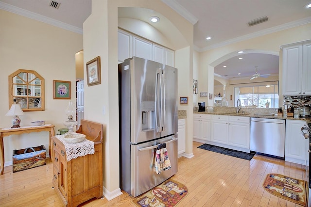 kitchen featuring appliances with stainless steel finishes, light hardwood / wood-style floors, white cabinetry, and light stone countertops