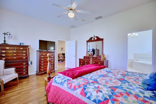 bedroom featuring light wood-type flooring, ensuite bathroom, and ceiling fan with notable chandelier