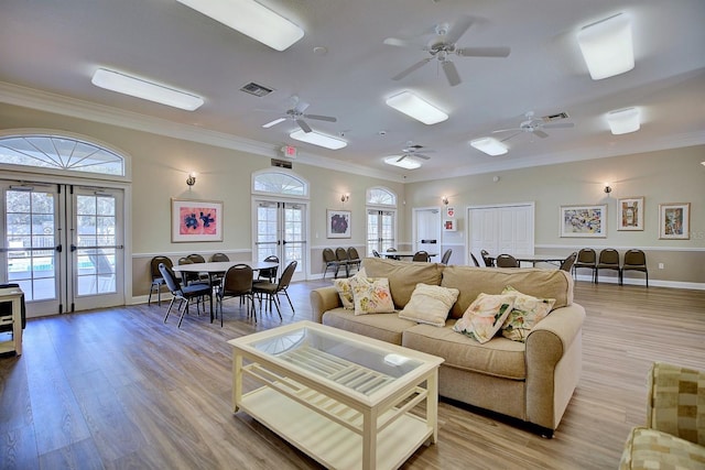 living room with french doors, light hardwood / wood-style floors, and plenty of natural light