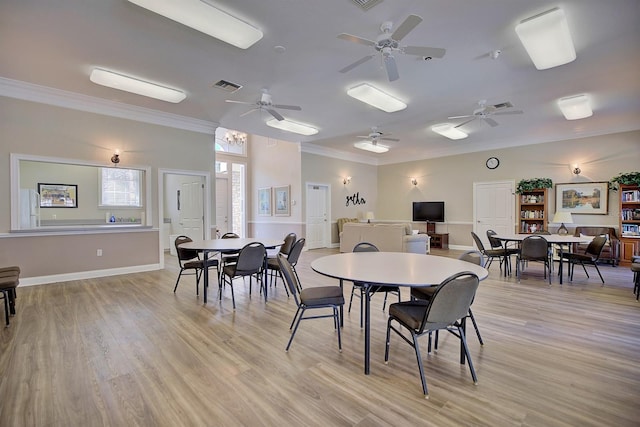 dining space featuring ornamental molding, light hardwood / wood-style floors, and a notable chandelier