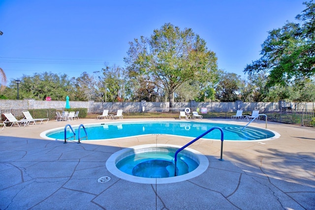 view of pool with a patio and a hot tub