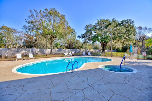 view of pool with a hot tub and a patio area