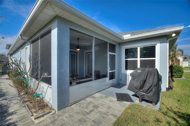 exterior space with a lawn, a sunroom, a patio, and ceiling fan