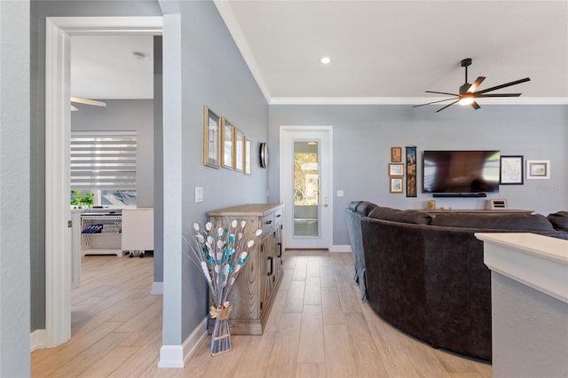 living room with ceiling fan, ornamental molding, and light wood-type flooring