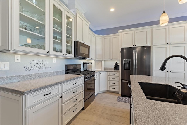 kitchen with hanging light fixtures, sink, white cabinetry, ornamental molding, and black appliances