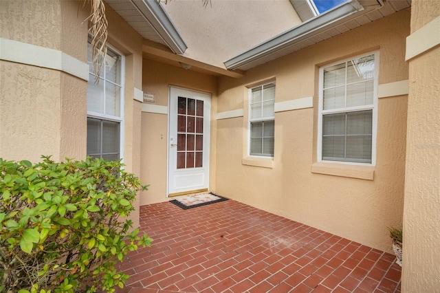 view of exterior entry with a patio