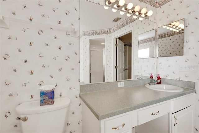 bathroom featuring toilet, a shower with door, and vanity