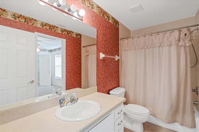 full bathroom featuring toilet, vanity, ceiling fan, and shower / bathtub combination with curtain