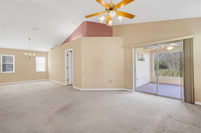 unfurnished living room with light colored carpet, lofted ceiling, and ceiling fan with notable chandelier