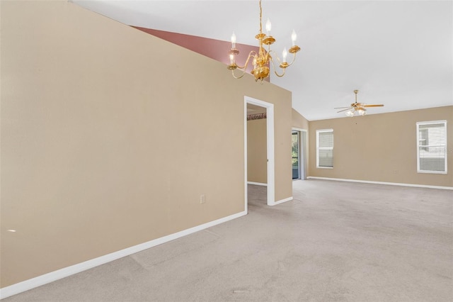 carpeted empty room with lofted ceiling and ceiling fan with notable chandelier