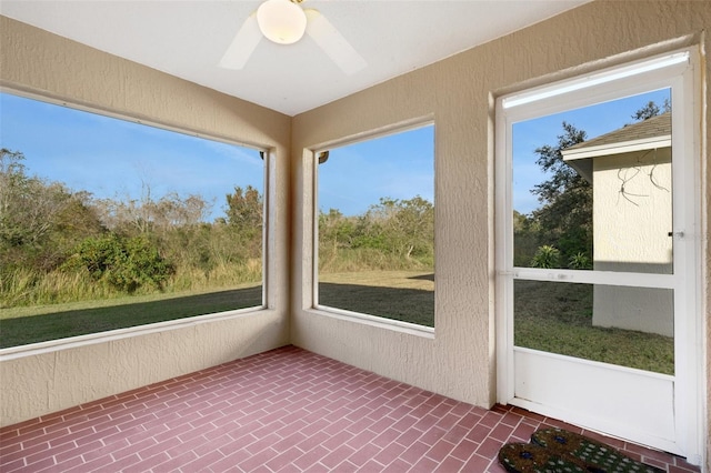 unfurnished sunroom with ceiling fan