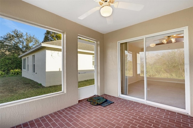 unfurnished sunroom with ceiling fan