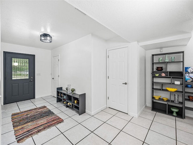 tiled entryway with a textured ceiling