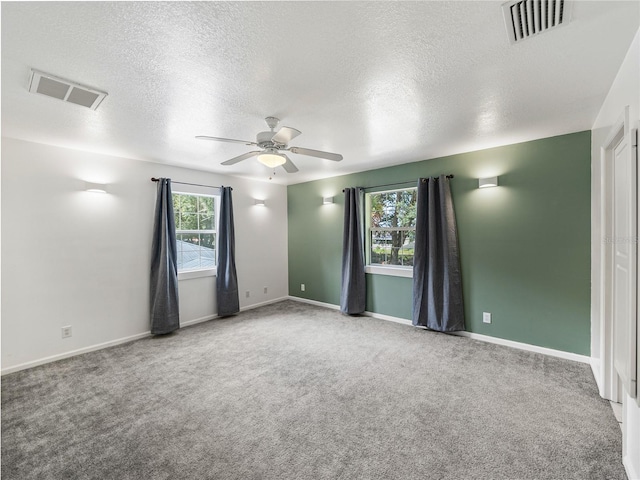 carpeted empty room with a textured ceiling and ceiling fan