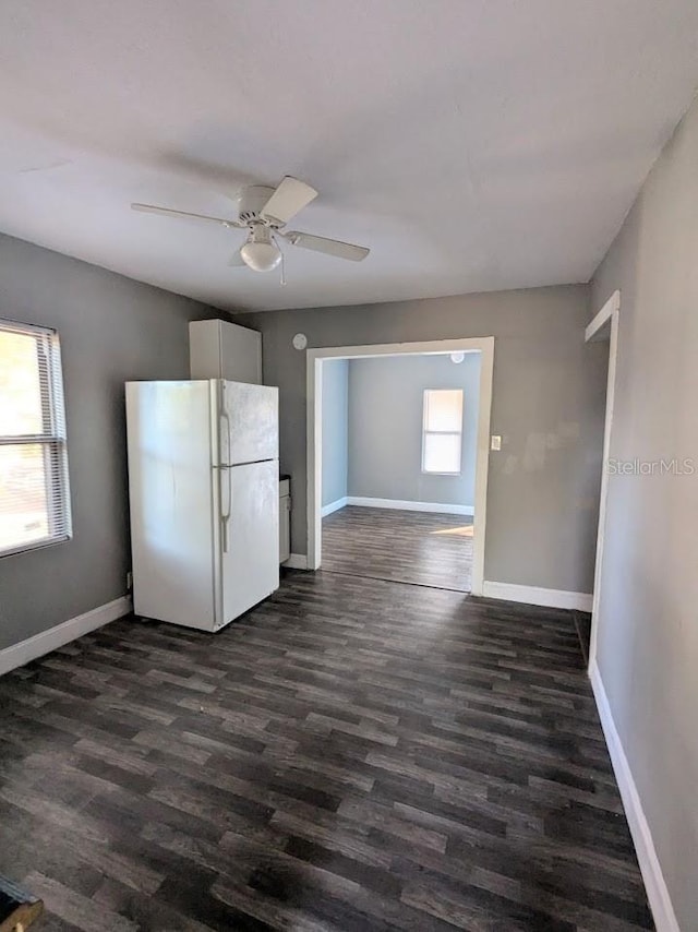 kitchen featuring white refrigerator, ceiling fan, dark hardwood / wood-style flooring, and white cabinetry