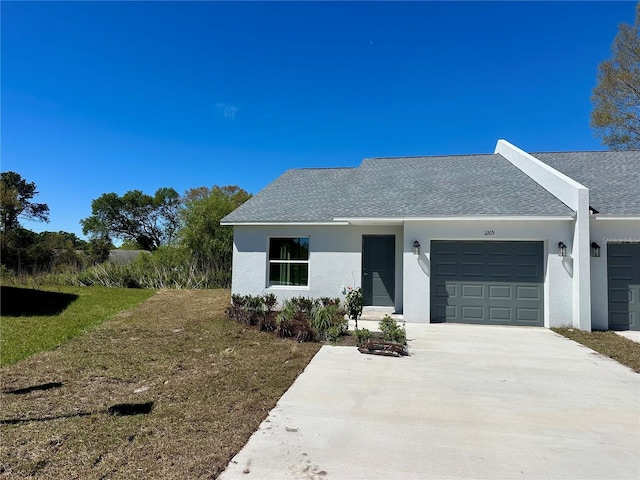 view of front facade featuring concrete driveway, roof with shingles, an attached garage, and stucco siding