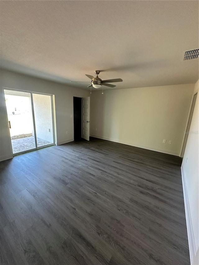 unfurnished room featuring ceiling fan, dark wood-type flooring, visible vents, and baseboards