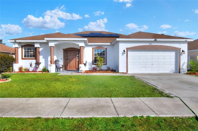 mediterranean / spanish-style home featuring an attached garage, solar panels, driveway, stucco siding, and a front lawn