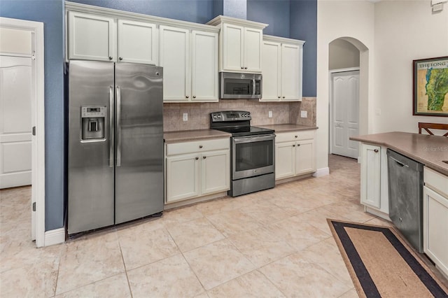 kitchen with tasteful backsplash, light tile patterned floors, and appliances with stainless steel finishes